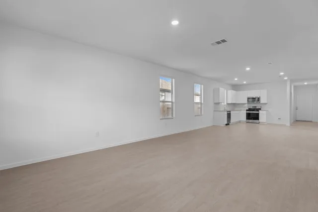 a view of empty room with kitchen
