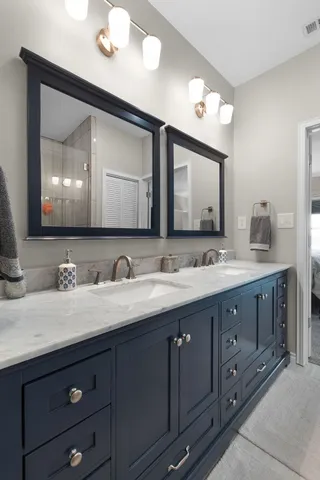 a bathroom with double sink and a mirror