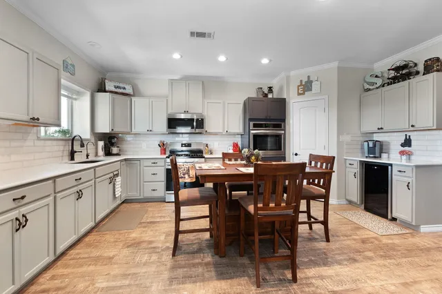a kitchen with kitchen island granite countertop wooden cabinets dining table and chairs