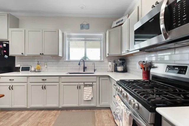 a kitchen with white cabinets and appliances