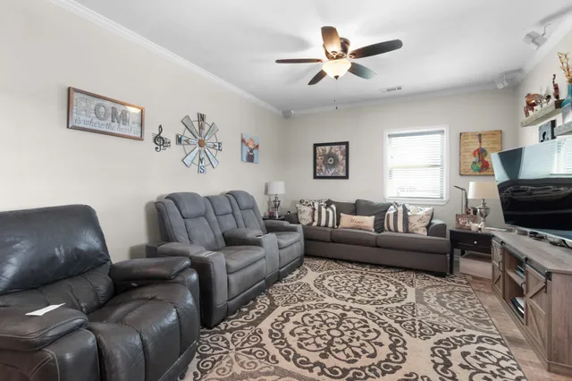 a living room with furniture a flat screen tv and a couch