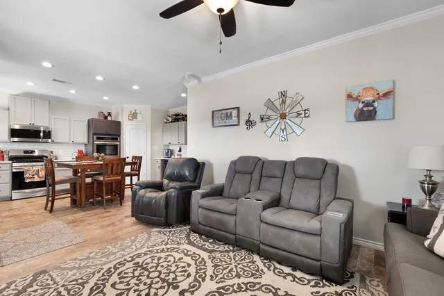 a living room with furniture kitchen view and a chandelier