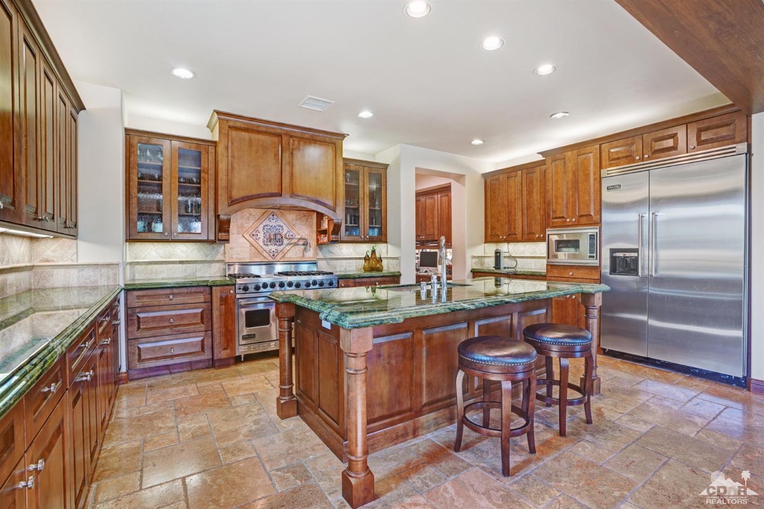 41 Cassis Circle Rancho Mirage, CA 92270 - Photo 3 of 68 a kitchen with stainless steel appliances granite countertop wooden cabinets a sink and a stove
