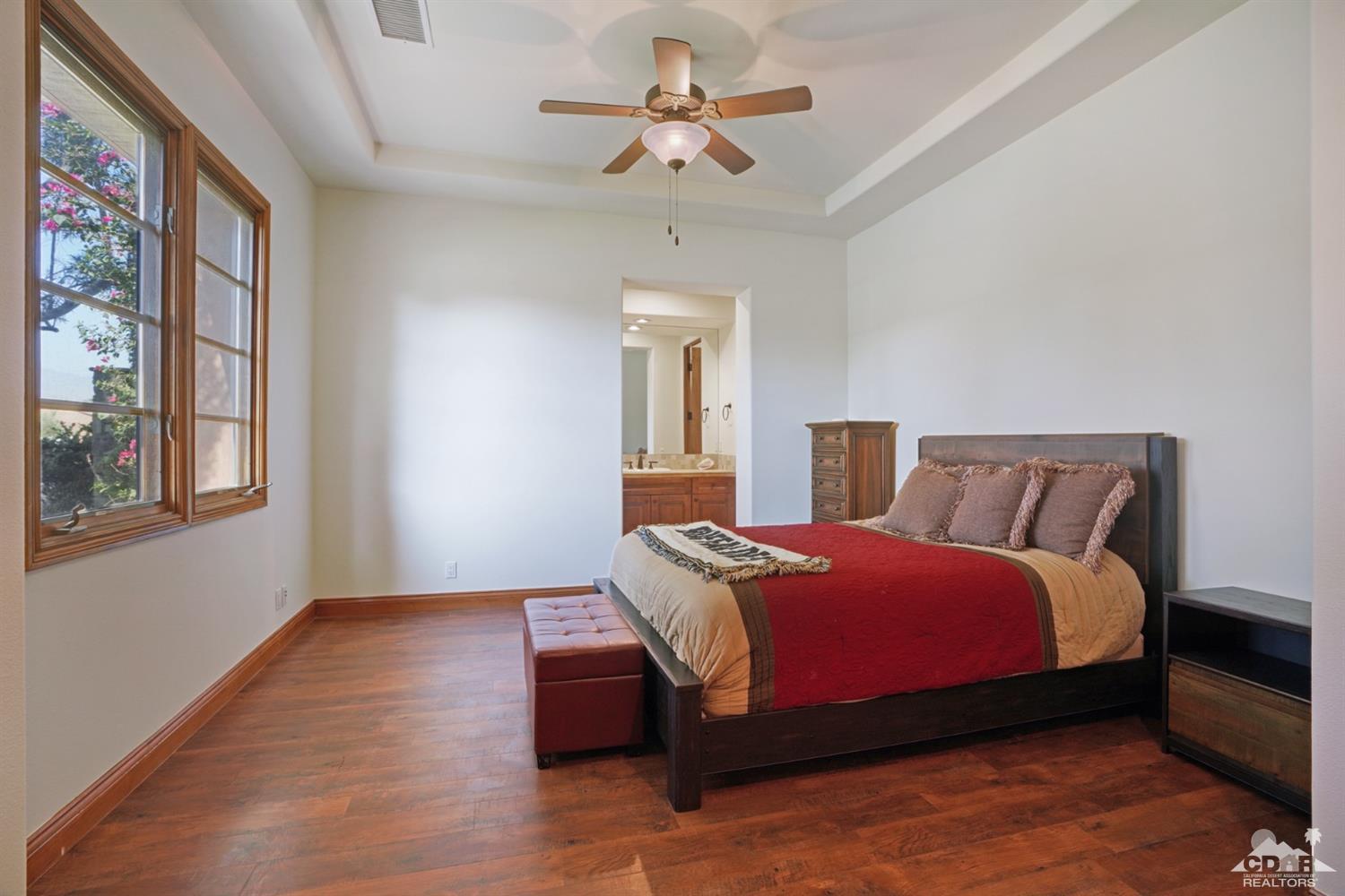 41 Cassis Circle Rancho Mirage, CA 92270 - Photo 31 of 68 a bedroom with a large bed and a chandelier