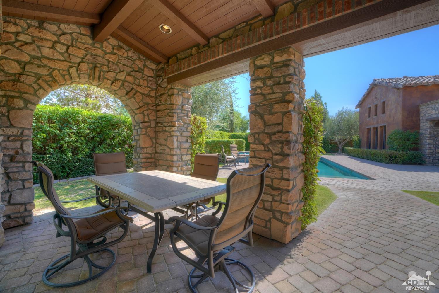 41 Cassis Circle Rancho Mirage, CA 92270 - Photo 44 of 68 a view of a patio with table and chairs with wooden floor and fence