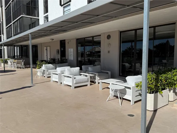 a view of a patio with table and chairs with wooden floor and fence