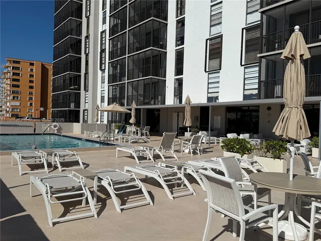a view of a patio with couches table and chairs and potted plants