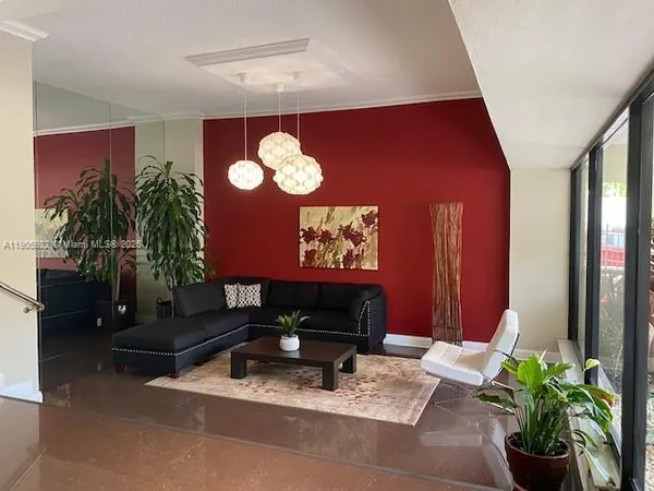 a living room with furniture chandelier and wooden floor