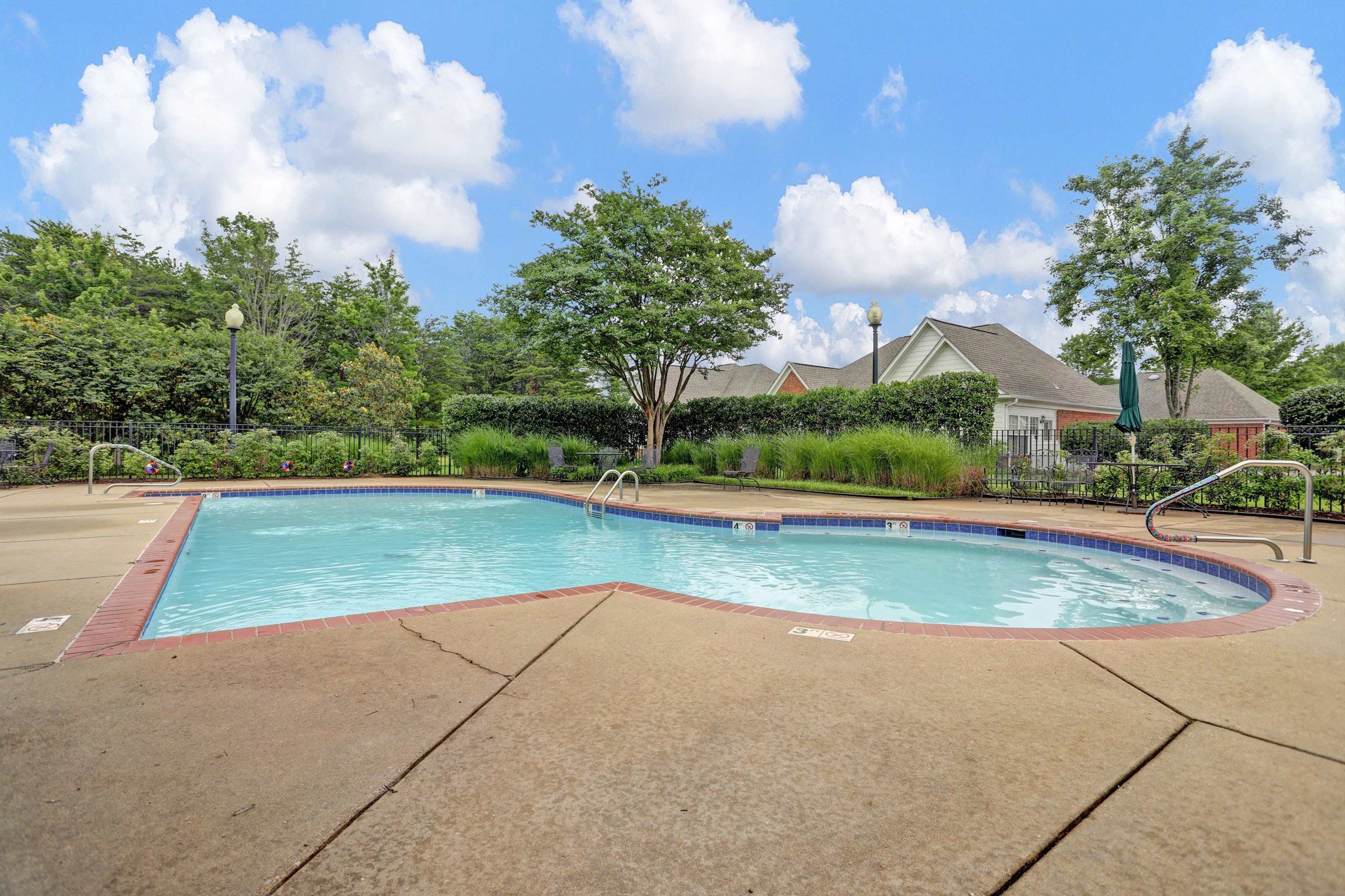 34 Peyton Ridge Drive, Unit 21 Collierville, TN 38017 - Photo 32 of 37 Outdoor swimming pool featuring a concrete deck, brick coping, and a dark blue tile waterline