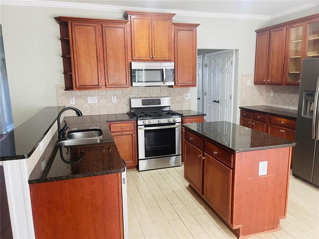1755 Wheat Grass Way Grayson, GA 30017 - Photo 12 of 42 a kitchen with granite countertop a sink stove and cabinets