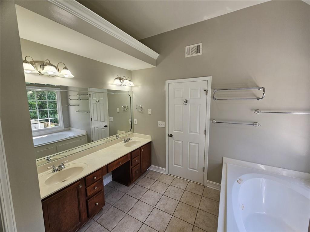 1755 Wheat Grass Way Grayson, GA 30017 - Photo 34 of 42 a bathroom with a double vanity sink a large mirror and a shower