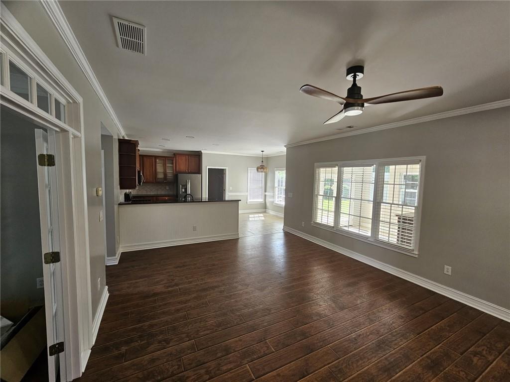 1755 Wheat Grass Way Grayson, GA 30017 - Photo 9 of 42 a view of a kitchen and an empty room with wooden floor and a kitchen