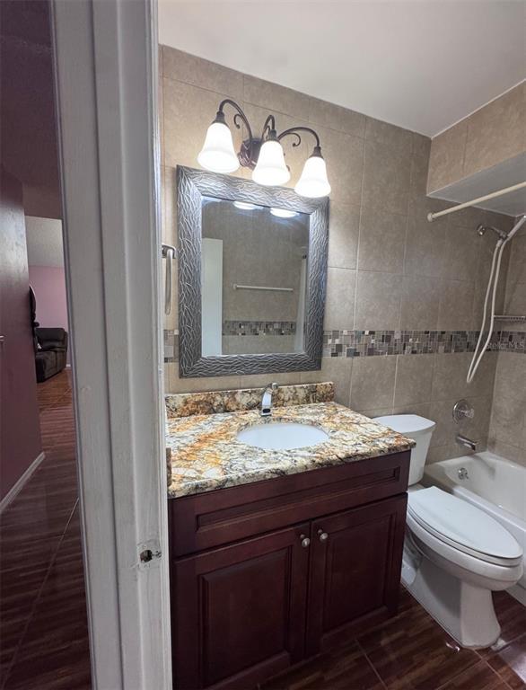 138 Pinewood Circle Kissimmee, FL 34743 - Photo 21 of 26 a bathroom with a granite countertop sink vanity mirror and toilet