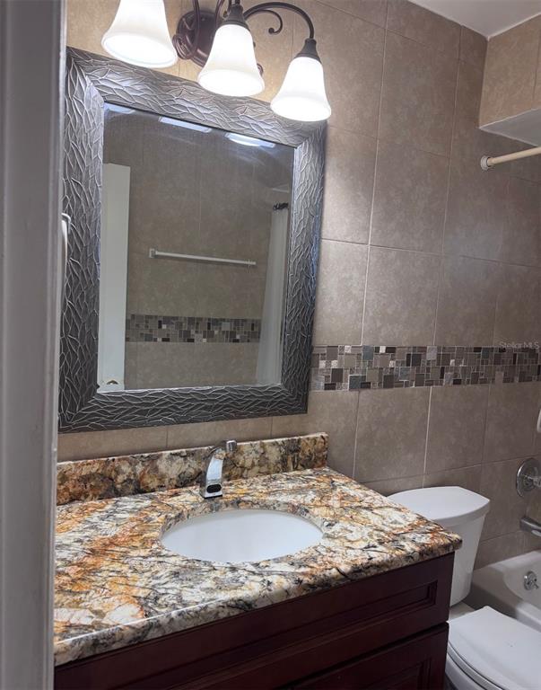 138 Pinewood Circle Kissimmee, FL 34743 - Photo 22 of 26 a bathroom with a granite countertop sink and a mirror