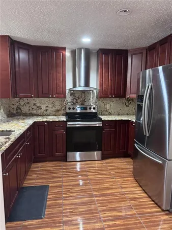 a kitchen with stainless steel appliances granite countertop a stove a refrigerator and a sink
