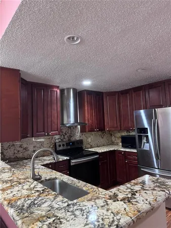 a kitchen with a refrigerator sink and cabinets