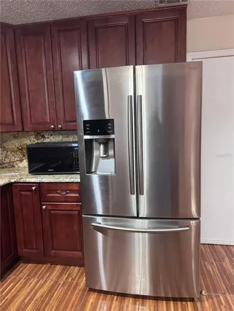 a kitchen with stainless steel appliances a refrigerator and a cabinets
