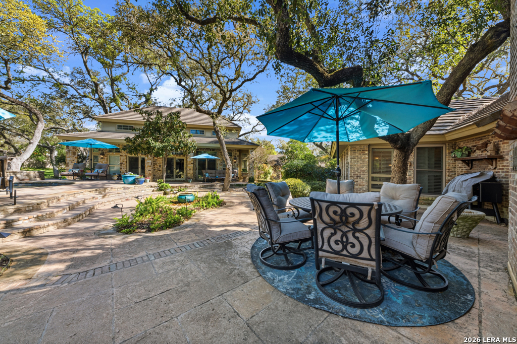 21749 Forest Waters Circle Garden Ridge, TX 78266 - Photo 30 of 50 a view of a patio with a table and chairs under an umbrella