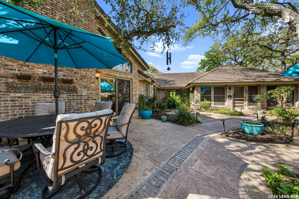 21749 Forest Waters Circle Garden Ridge, TX 78266 - Photo 31 of 50 a patio with a table and chairs under an umbrella