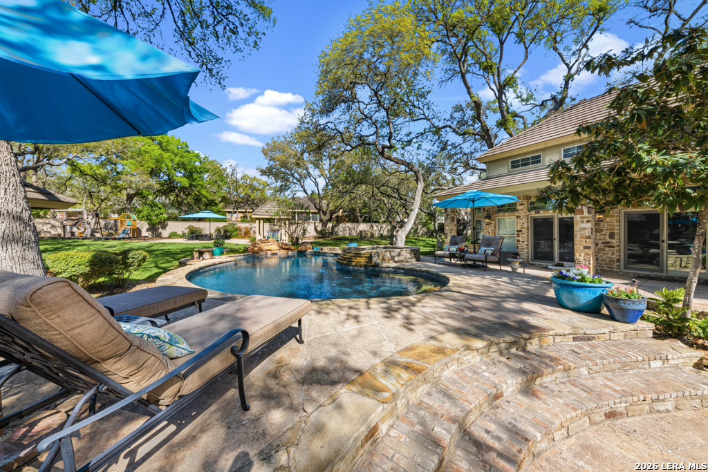 21749 Forest Waters Circle Garden Ridge, TX 78266 - Photo 33 of 50 a view of a patio with table and chairs under an umbrella