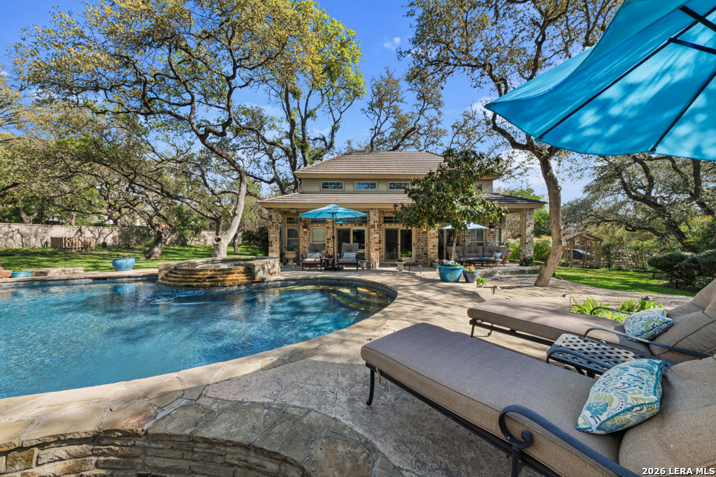 21749 Forest Waters Circle Garden Ridge, TX 78266 - Photo 34 of 50 a view of a patio with table and chairs under an umbrella