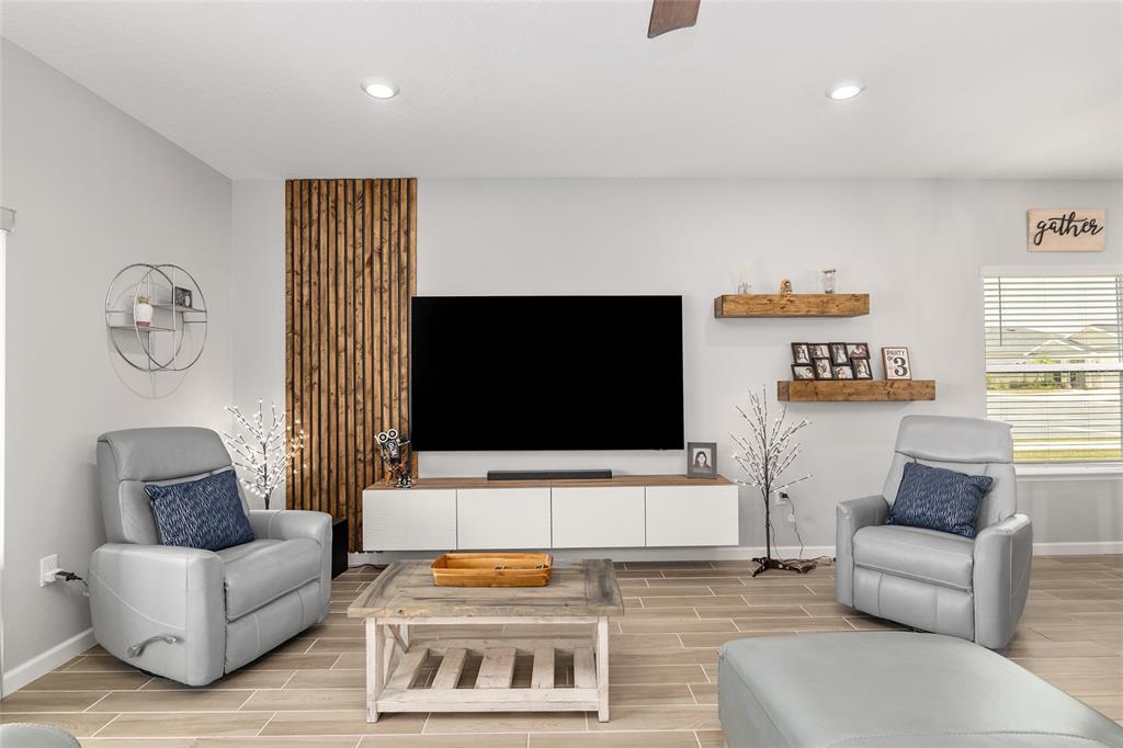 5688 Southwest 92nd Place Ocala, FL 34476 - Photo 13 of 54 a living room with furniture and a flat screen tv
