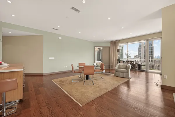 a living room with furniture a large window and wooden floor