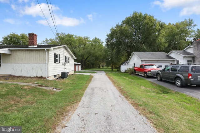 a view of a house with a yard and large tree