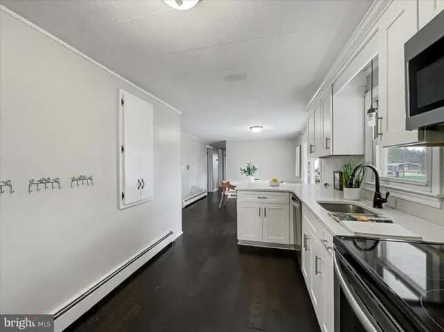 a kitchen with granite countertop white cabinets and white appliances