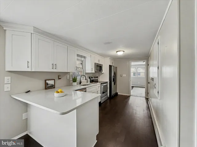 a view of kitchen with sink refrigerator and cabinets