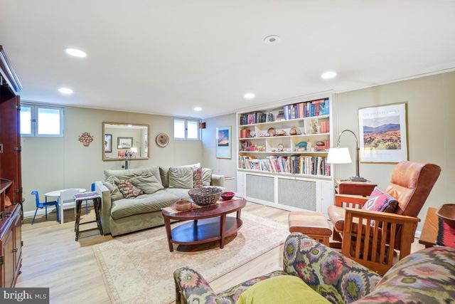 a kitchen that has a lot of white cabinets and wooden floor