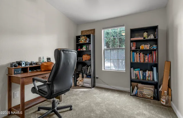 a view of a workspace with furniture and a bookshelf