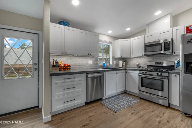 a kitchen with stainless steel appliances granite countertop a stove a sink and a microwave