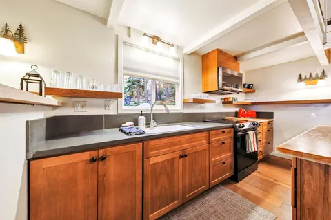 a kitchen with stainless steel appliances granite countertop a sink stove and cabinets