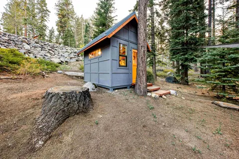 a view of a small house with wooden fence