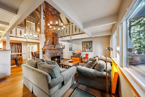 a living room with fireplace furniture and a large window