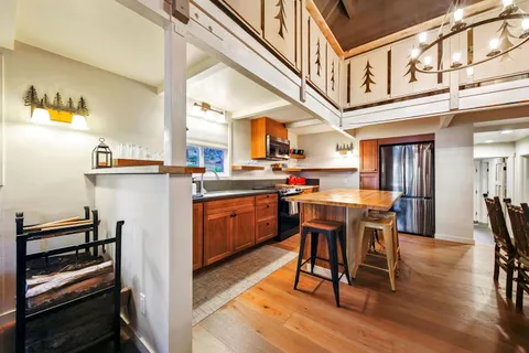a kitchen with stainless steel appliances a table chairs and a refrigerator