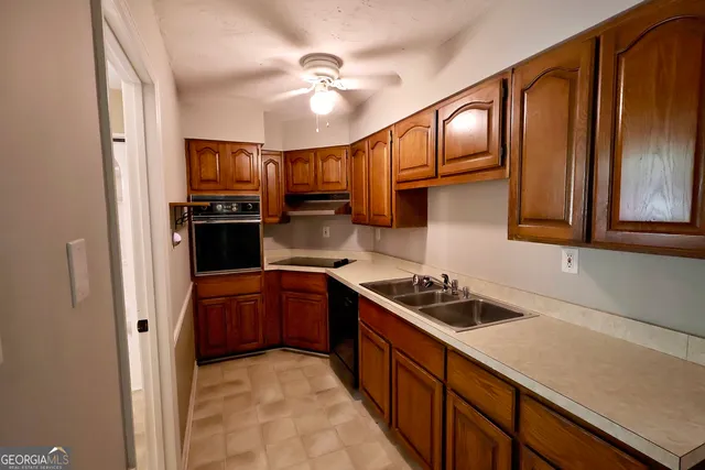 a kitchen with stainless steel appliances granite countertop a sink refrigerator stove and microwave