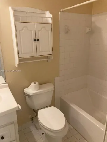 a white toilet sitting next to a bath tub