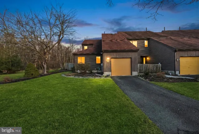 a front view of a house with a garden and yard
