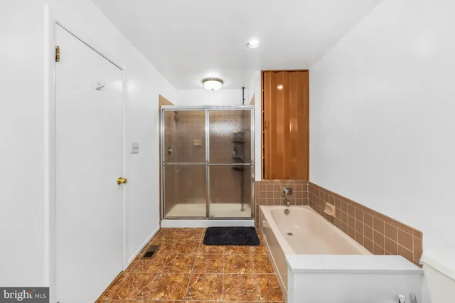 a bathroom with a bathtub sink mirror and toilet