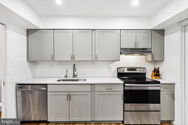 a kitchen with white cabinets sink and white appliances