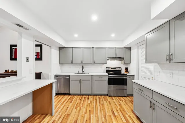 a large kitchen with stainless steel appliances granite countertop a stove sink and cabinets