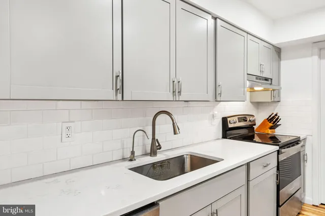a view with a sink a counter and cabinets
