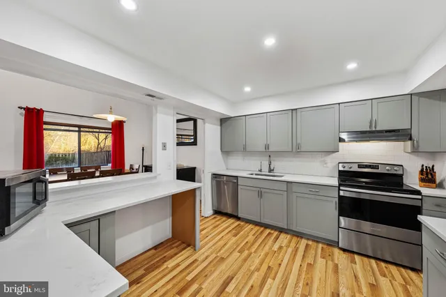 a large kitchen with stainless steel appliances granite countertop a stove and a sink