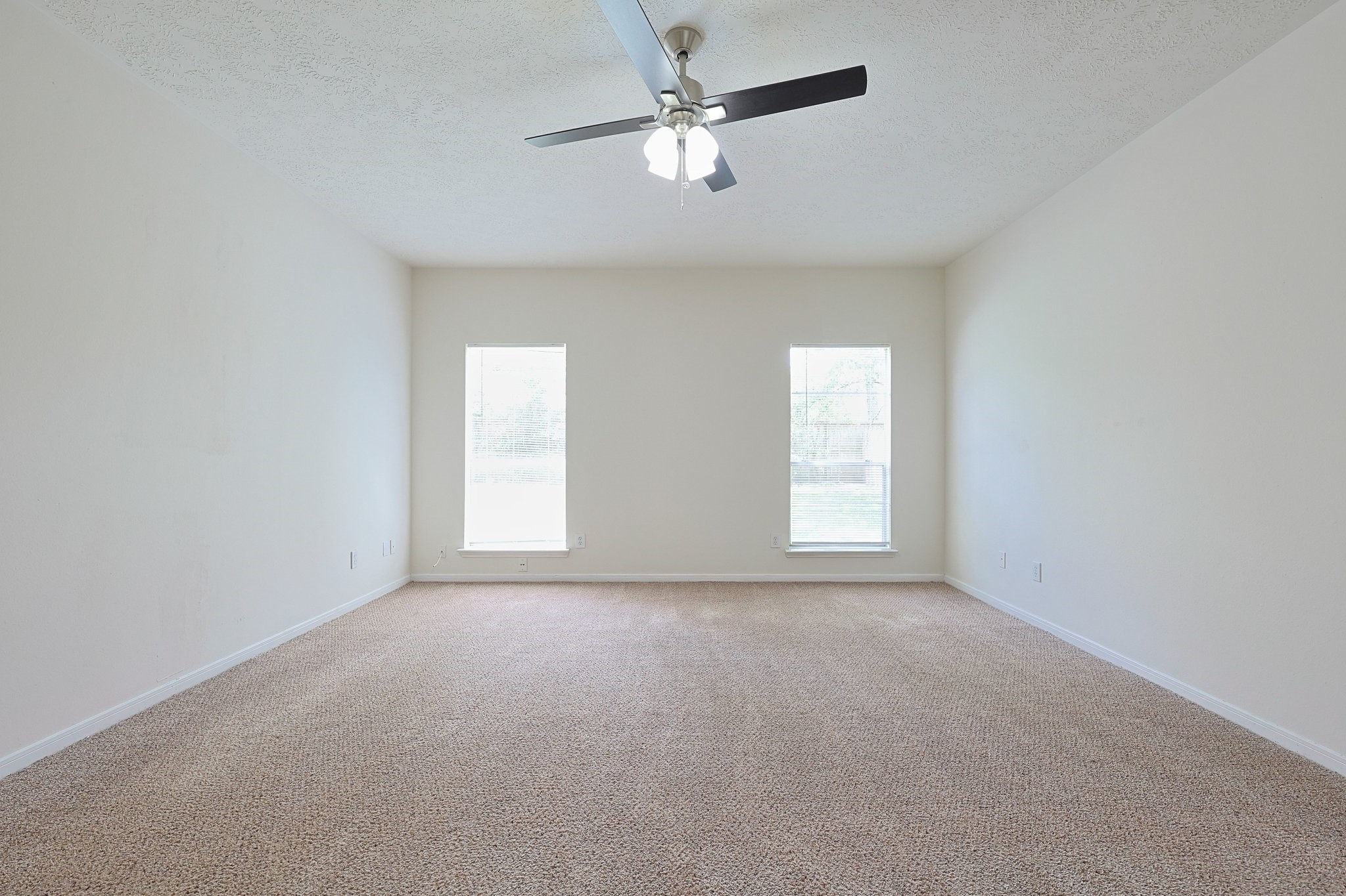 23019 Eastgate Village Drive Spring, TX 77373 - Photo 37 of 46 This spacious room features neutral carpeting, two large windows for natural light, and a ceiling fan, offering a bright and airy feel.