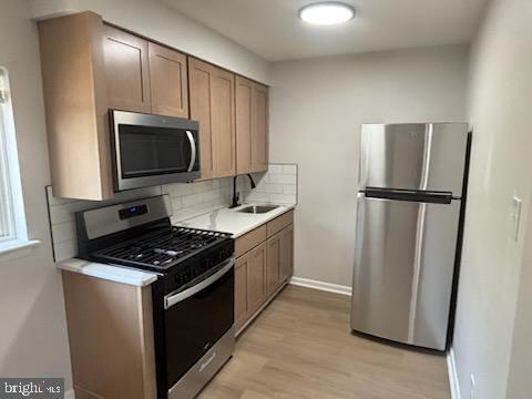 a kitchen with stainless steel appliances a refrigerator a stove a microwave and cabinets