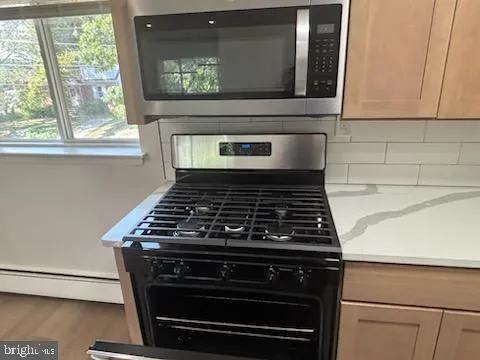 a stove top oven sitting inside of a kitchen