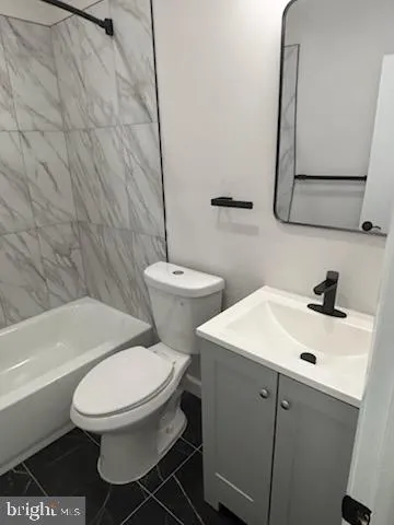 a white toilet sitting next to a bathroom sink