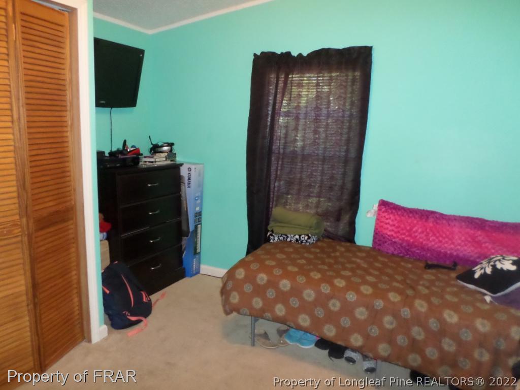 552 Lakerun Drive Bunnlevel, NC 28323 - Photo 21 of 31 a bedroom with a bed and a flat tv screen on dresser